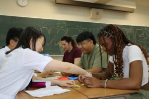 折り鶴の折り方を教える生徒